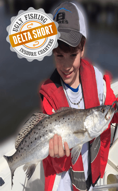 boy holding speckled trout on mobile delta