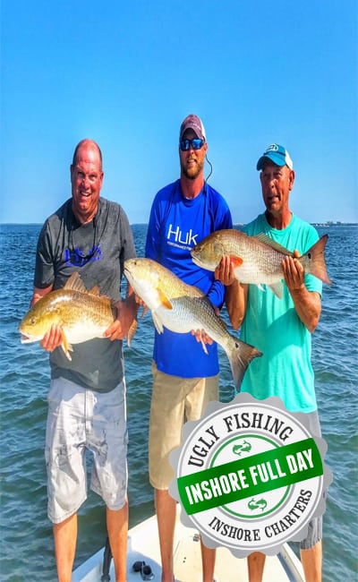 Men holding redfish on boat in Mobile Bay